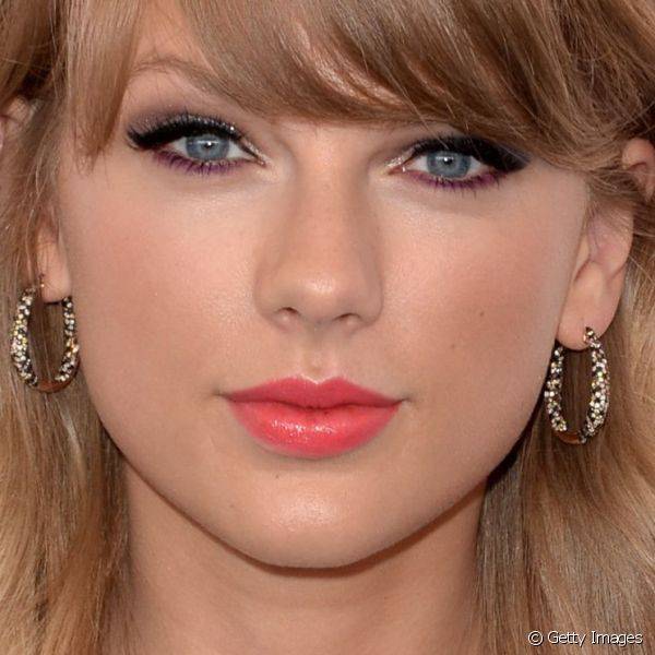 Taylor Swift estava colorida da cabe?a aos p?s e para a make usou um batom rosa chiclete, al?m de uma mistura de delineadores roxo e preto para o Teen Choice Awards 2014